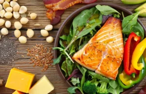 High Fat Low Carb Foods: Beyond Bacon & Avocado? Diverse high-fat low-carb foods like salmon, nuts, seeds, cheese, and vegetables, showing options beyond just bacon and avocado.