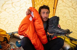 Mount Everest Climbing Gear: Rent vs Buy Decision Climber contemplating the Mount Everest climbing gear rent vs buy decision inside a base camp tent.