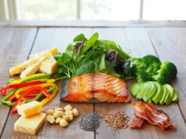 Diverse high-fat low-carb foods like salmon, nuts, cheese, and vegetables, questioning if the diet is just Keto or something else.