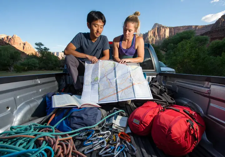 Planning your Zion ascent: climbers reviewing maps and gear for big wall logistics in the National Park.