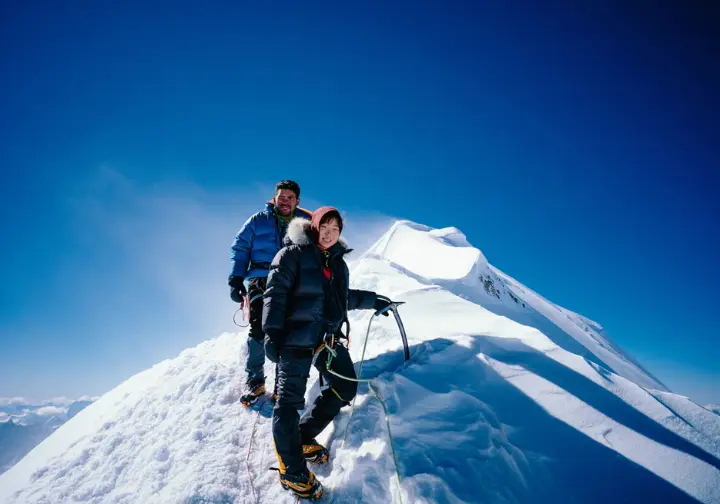 Two climbers on a snowy Everest ridge during the quieter, colder post-monsoon autumn season, an alternative best time to climb.