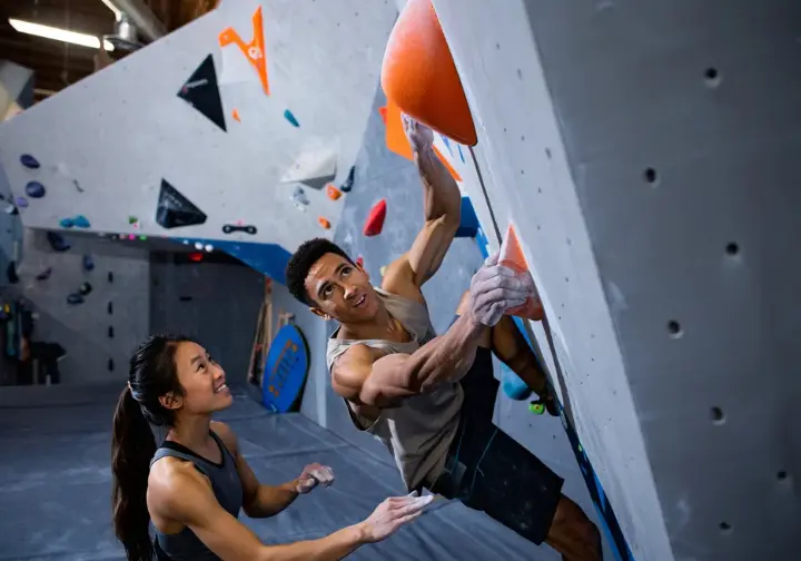 Benchmark Climbing Berkeley: a modern bouldering experience with diverse climbers collaborating on a problem.