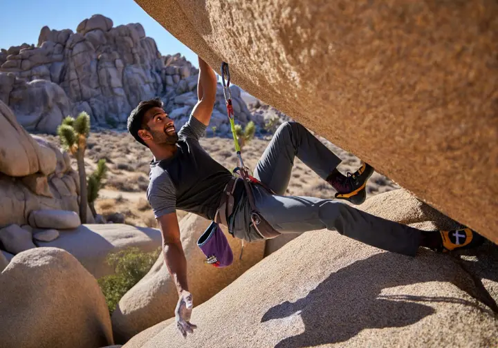 Climber navigating key bouldering areas in Joshua Tree's granite maze, using a guidebook for this joshua tree bouldering guide.