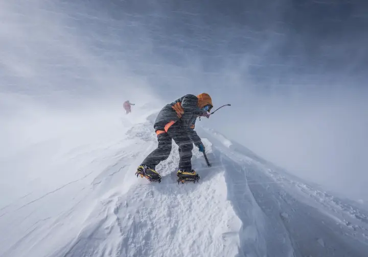 Lone climber battling extreme winter conditions on Everest, highlighting the risks of off-season attempts and not the best time to climb.