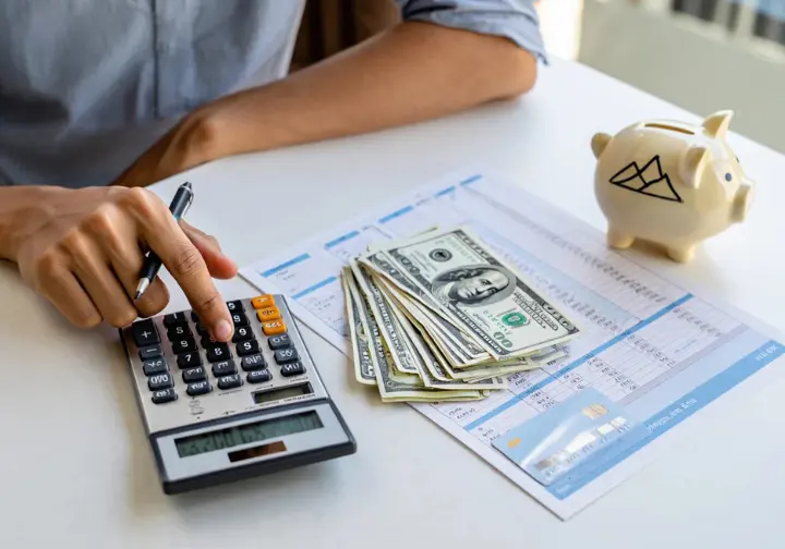 Financial realities of climbing Mount Everest: hand with calculator, money, and budget spreadsheet detailing expedition costs as prerequisites.