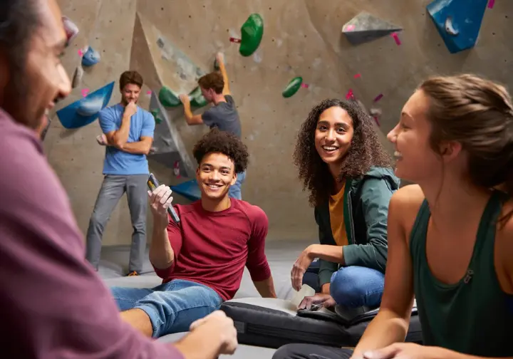 Community pick review of Mosaic Boulders: diverse young climbers socializing in the welcoming atmosphere of this Berkeley rock climbing gym.