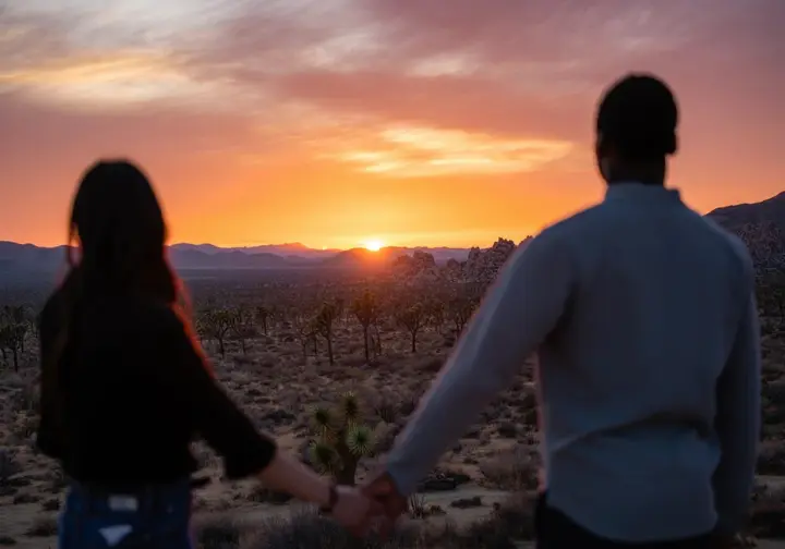 Couple enjoying a panoramic sunset view in Joshua Tree National Park, highlighting activities beyond bouldering for a joshua tree bouldering guide.