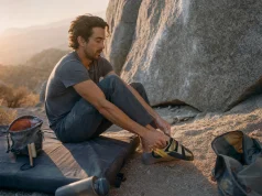 Best Climbing Shoes for Bouldering Without the Foot Pain Boulderer pulling on La Sportiva Skwama shoes on a crash pad before a last attempt at dusk