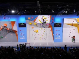 Panoramic view of an IFSC World Cup arena showing athletes competing in Boulder, Lead, and Speed climbing, providing a guide to the formats, rules, and rounds.