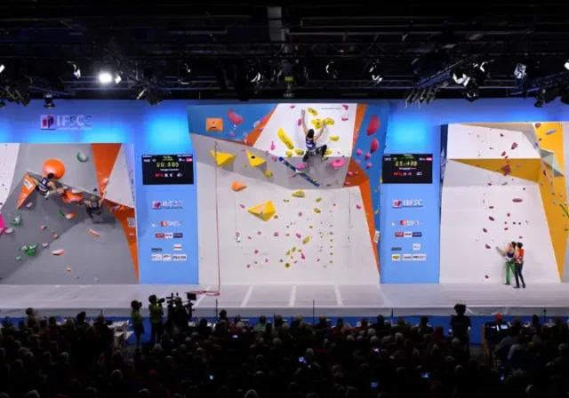 Panoramic view of an IFSC World Cup arena showing athletes competing in Boulder, Lead, and Speed climbing, providing a guide to the formats, rules, and rounds.