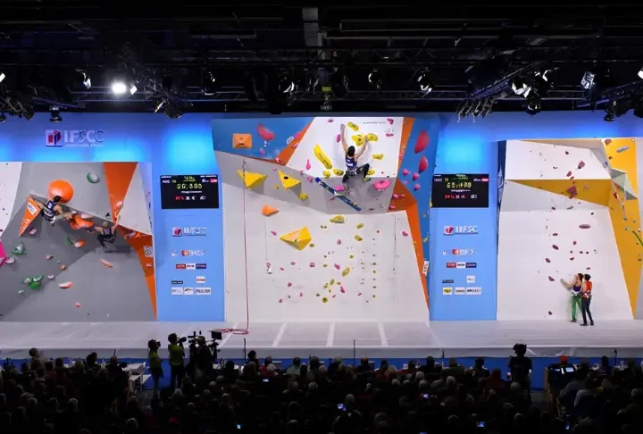 Panoramic view of an IFSC World Cup arena showing athletes competing in Boulder, Lead, and Speed climbing, providing a guide to the formats, rules, and rounds.