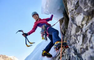 Master Ice & Rock: Mixed Climb Transition Guide Skilled mixed climber transitioning from ice to rock, using ice tools and crampons on both surfaces, illustrating a guide to mastering mixed climbing essentials.