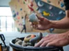 The Setter’s Secret: How Gym Climb Grades Emerge Close-up of route setter's hands selecting a climbing hold, symbolizing the secret of how gym climb grades emerge through route setting.