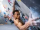 Build Bouldering Power, Finger & Lock-off Strength Boulderer executing a powerful move on an indoor wall, showcasing bouldering power, strong finger grip, and a solid lock-off, for a guide on building these strengths.