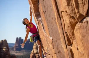 North America’s Top Sport Climbing: Must-Do Crags Climber on a striking sport route, with glimpses of diverse North American crags (sandstone, limestone, granite) in the background, representing top sport climbing destinations you can't miss.