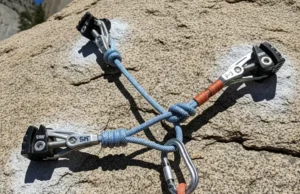 Trad Anchors: Build Bombproof with SERENE/ERNEST Perfectly constructed bombproof trad climbing anchor on granite, showcasing SERENE/ERNEST principles with cams, nuts, and an equalized cordelette master point.
