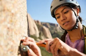 Trad Climbing Ethics and Leave No Trace: Protecting the Crags Trad climber carefully cleaning gear or brushing a hold on a pristine granite cliff, demonstrating trad climbing ethics, Leave No Trace principles, and a climber's duty for crag care.