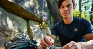 Trad Rack Building: Prioritize Your Essential Gear Climber organizing essential trad rack components (nuts, cams, alpine draws, nut tool) at a granite crag, prioritizing gear for building their first trad rack.