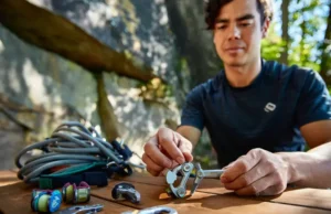 Trad Rack Building: Prioritize Your Essential Gear Climber organizing essential trad rack components (nuts, cams, alpine draws, nut tool) at a granite crag, prioritizing gear for building their first trad rack.