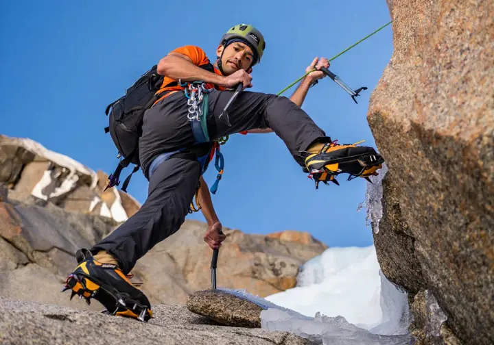 Mixed climber demonstrating core techniques by skillfully using ice tools and crampons on both rock and ice sections of a challenging alpine route, mastering mixed terrain transitions.