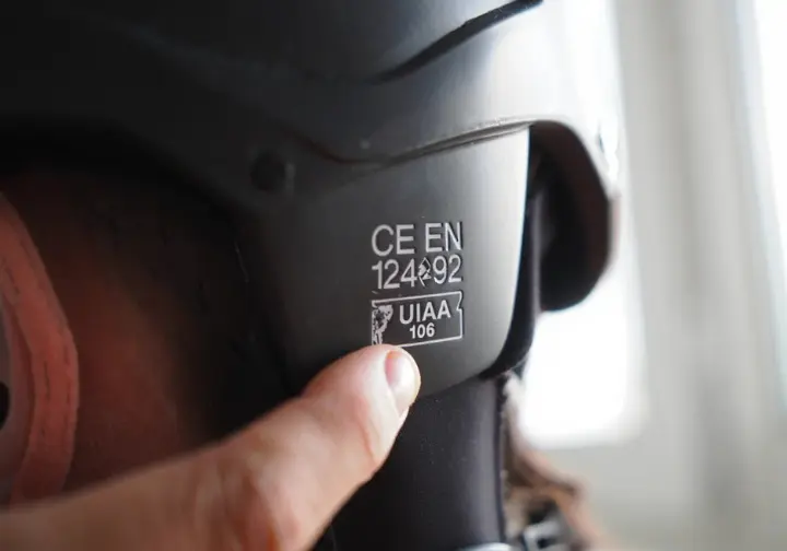 Close-up of CE EN 12492 and UIAA 106 certification marks on a climbing helmet, essential for understanding helmet safety standards.