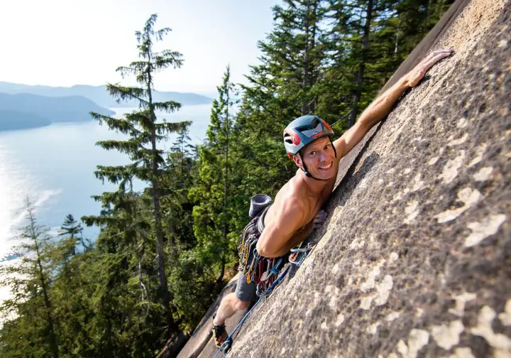 Sport climber on a distinctive rock type: coastal granite (e.g., Squamish), classic schist (e.g., Rumney), or vibrant desert sandstone (e.g., Red Rock Canyon).