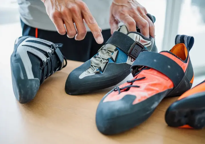 Close-up of three different climbing shoes highlighting specific features beneficial for advanced bouldering: downturn for dynos, secure heel cup for heel hooks, and rubber toe patch for toe hooks.