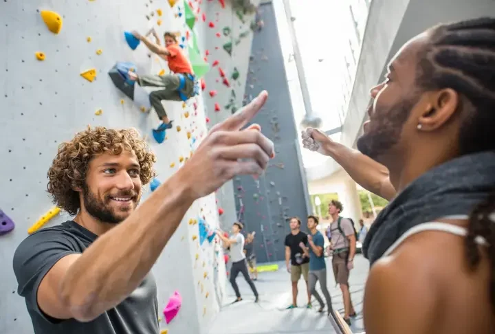Diverse climbers ascend a massive, modern artificial climbing wall, symbolizing the challenge and scale of the largest climbing walls in the world.