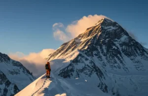 Climb Everest: The Definitive Cost & Training Guide A climber gazes at the sun-drenched peak of Mount Everest from a ridge, representing the start of a trip to climb the mountain and a definitive guide to cost and training.