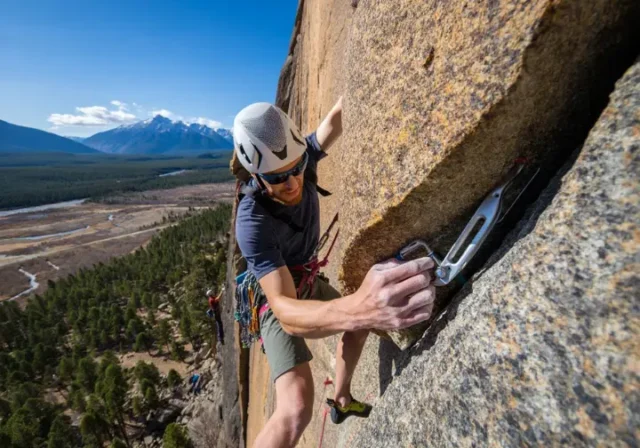 A climber on a rock face, demonstrating the ethics and craft of a modern first ascent in a natural outdoor setting.