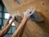 Mastering the Hangboard: A Beginner’s Training Plan Hands of two diverse climbers gripping a wooden hangboard, representing a beginner's training plan for finger strength in rock climbing.