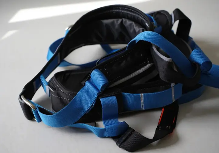 Close-up of a women's rock climbing harness, clearly showing its waistbelt, leg loops, belay loop, and gear loops, highlighting its anatomy.