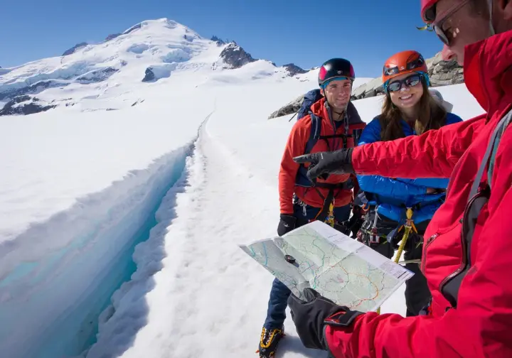 Climbers and a guide at a snowy crossroads on Mount Baker, symbolizing a decision framework for choosing a guided Mt Baker climb.