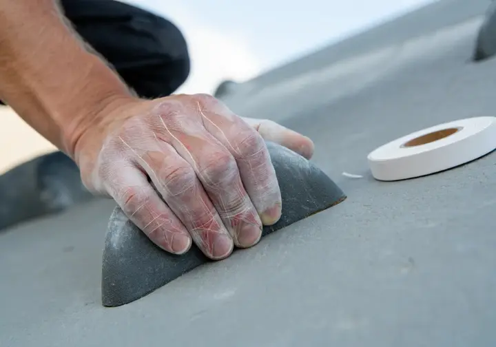 A climber's hand on a climbing hold with a subtle overlay depicting finger anatomy, next to rock climbing finger tape, representing the science behind taping.