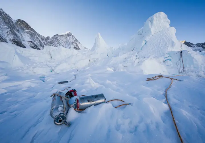 A wide, photorealistic image of the Khumbu Icefall on Mount Everest, subtly showing signs of environmental impact and human presence, representing broader context and future challenges.