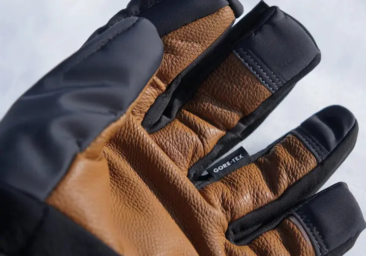 Close-up of an ice climbing glove, highlighting the goatskin leather palm, waterproof membrane, and synthetic insulation, explaining handwear technology.