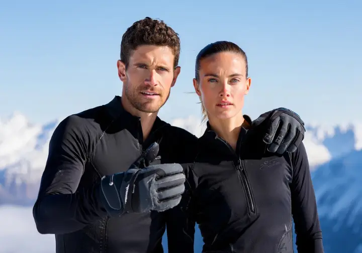 Two ice climbers, male and female, showcasing high-performance ice climbing gloves in a snowy mountain environment, representing expert recommendations.
