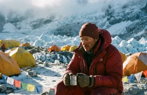 Why a Trip to Climb Mount Everest Is 90% Waiting Climber in a red down suit resting at Everest Base Camp below the Khumbu Icefall at dawn