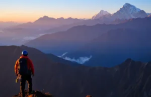 World’s Best Climbs: From Trekking Peaks to Summits A climber overlooks a vast mountain range at sunrise, with accessible trekking peaks in the foreground and towering technical summits like Denali or Everest in the distance.