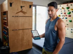 Climbing Assessment: A Data-Backed Framework to Find & Fix A dedicated climber analyzes performance data on a tablet in their home training area, demonstrating a data-backed framework to assess and fix climbing weaknesses.