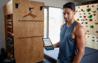 Climbing Assessment: A Data-Backed Framework to Find & Fix A dedicated climber analyzes performance data on a tablet in their home training area, demonstrating a data-backed framework to assess and fix climbing weaknesses.