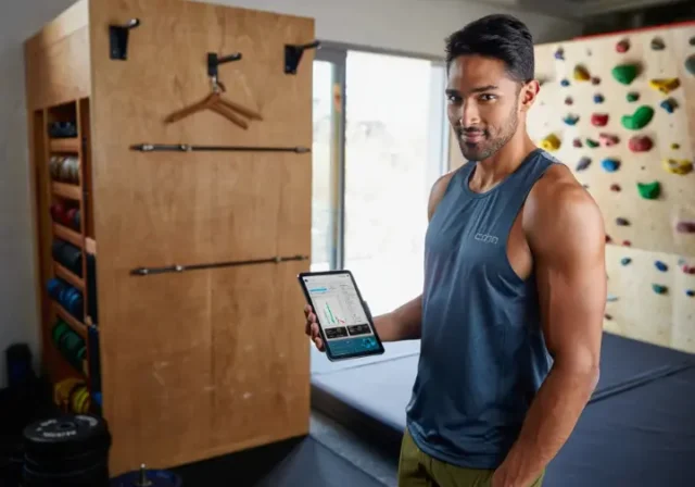 A dedicated climber analyzes performance data on a tablet in their home training area, demonstrating a data-backed framework to assess and fix climbing weaknesses.