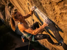 A determined climber fights through forearm pump high on a steep rock face, illustrating the central theme of the science of climbing endurance and training.