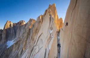 Mastering Mt Whitney’s East Face: A Complete Beta Wide view of the sunlit East Face of Mt. Whitney with two climbers on the route, showcasing the scale of the classic alpine climb.