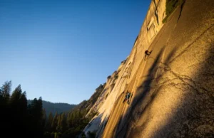 Yosemite Rock Climbing: The Definitive Guide to Routes & Permits Two climbers ascend the massive granite face of El Capitan during golden hour, representing the challenge of rock climbing in Yosemite National Park.