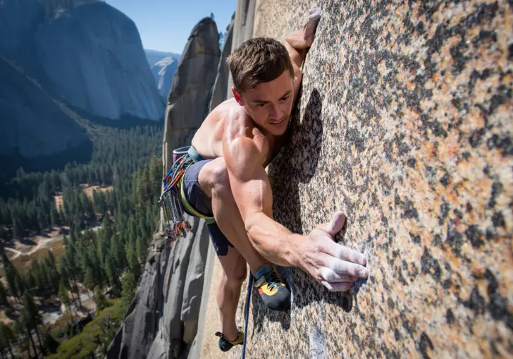 A skilled rock climber places a solid hand jam while leading a classic granite route in Yosemite National Park.