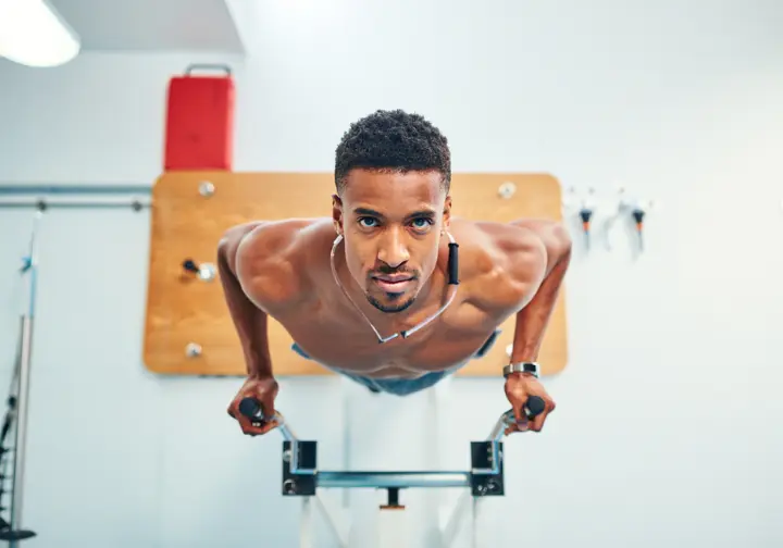 An elite athlete trains on a campus board while wearing a heart rate monitor, illustrating the science of performance for low-carb diets in athletics.