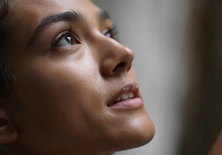An intense close-up on a climber's face shows deep concentration and mental fortitude, illustrating the brain's critical role in managing and overcoming physical fatigue.