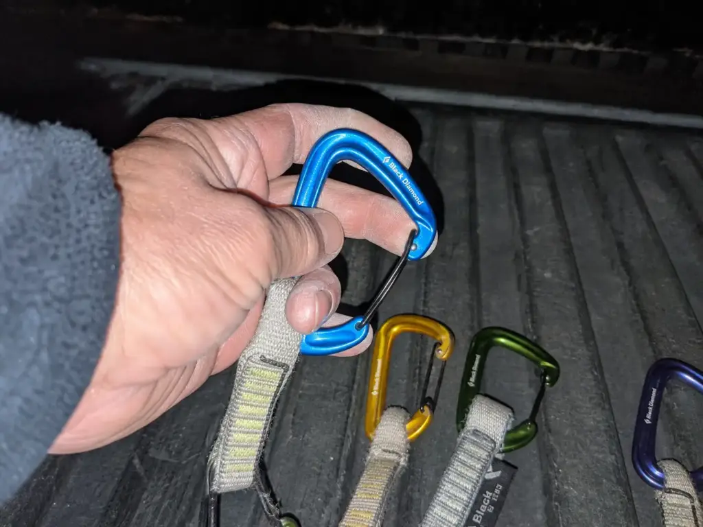 Running a finger inside a rope-end carabiner basket to feel for a worn groove