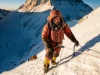 What an Everest Expedition Really Costs in 2026 Climber in a red down suit ascending a fixed line high on Everest at dawn on a 2026 expedition